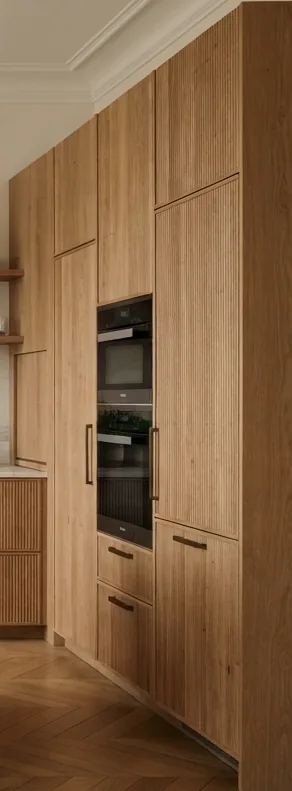 Tall fluted oak cabinets with integrated ovens